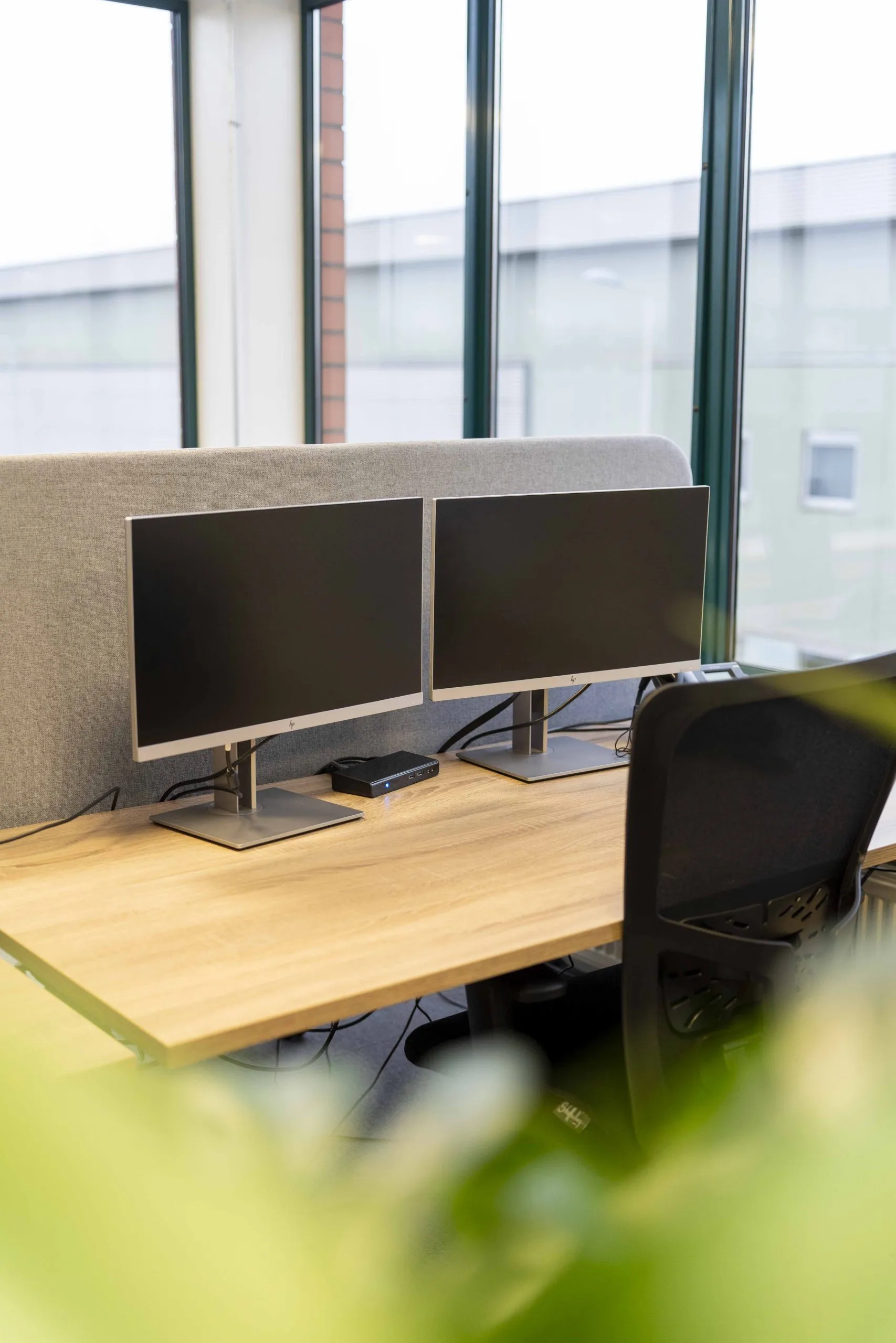 Werkplek met dubbele monitoren bij raampartij